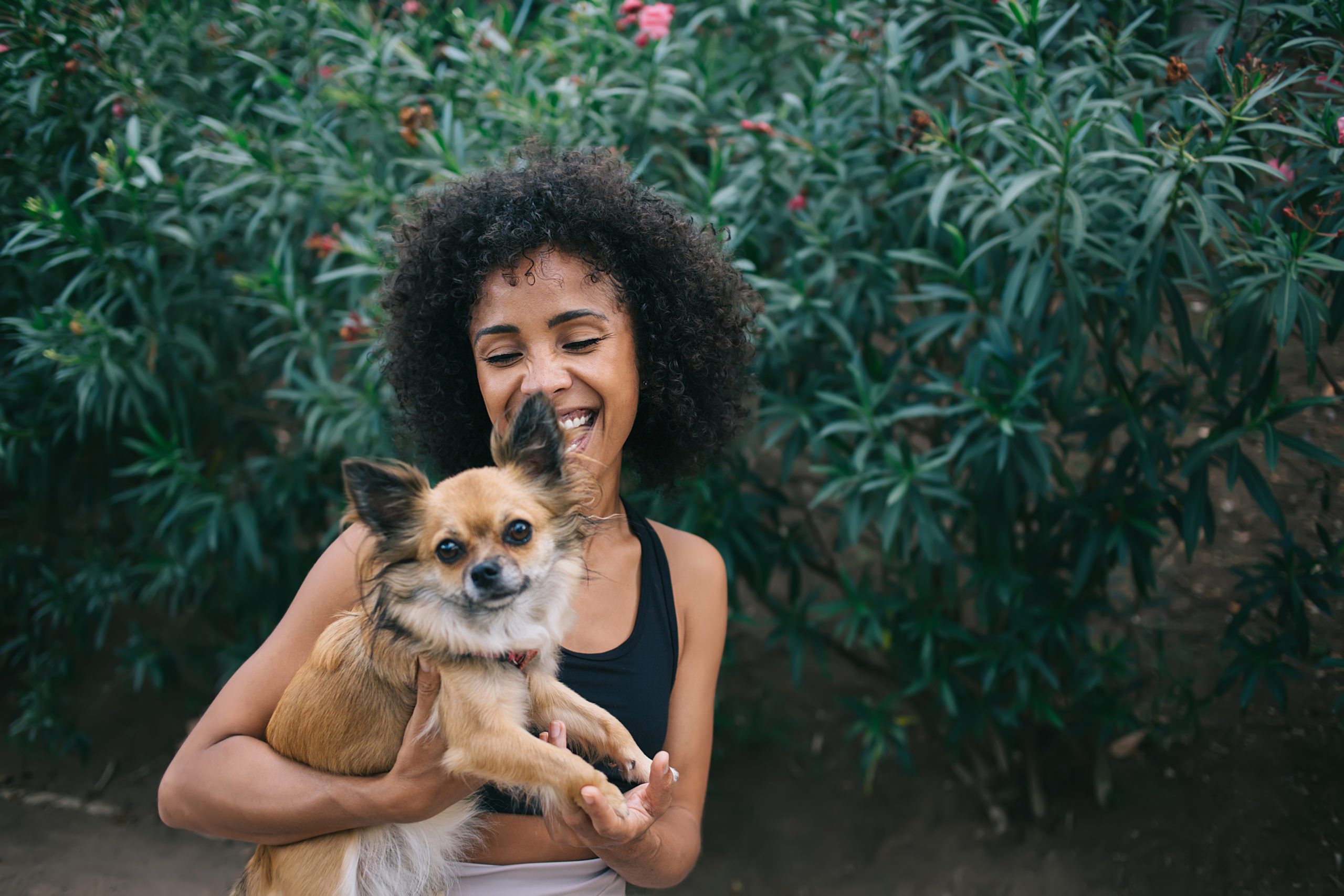 Excited Young Black Woman With Obedient Dog Outside